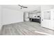 Open-concept living room with gray wood-look flooring flowing into the kitchen with a center island and white cabinetry at 603 Mt. Wesley Church Rd, Hiddenite, NC 28636