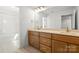 Spacious bathroom with double sinks, wooden cabinets, and large mirrors at 605 Arrow Point Ln, Davidson, NC 28036