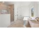 Bright bathroom featuring a glass-enclosed shower, soaking tub, and double sink vanity at 605 Arrow Point Ln, Davidson, NC 28036