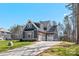 Beautiful home showcasing architectural shingles, a well-maintained lawn, and a three-car garage with a pergola at 605 Arrow Point Ln, Davidson, NC 28036