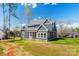 Rear view of a two-story home featuring gray siding, a gray roof, and an expansive lawn at 605 Arrow Point Ln, Davidson, NC 28036