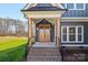 Inviting front entryway with a stylish wooden door, brick steps, and dark metal railings, showcasing great curb appeal at 605 Arrow Point Ln, Davidson, NC 28036