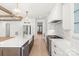 Modern kitchen with a dark island, stainless steel appliances, and pristine white cabinetry, creating a culinary dream space at 605 Arrow Point Ln, Davidson, NC 28036