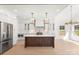Bright, open-concept kitchen with stainless steel appliances, white cabinetry, and a large center island at 605 Arrow Point Ln, Davidson, NC 28036