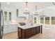 Bright kitchen featuring white cabinetry, a large island, stainless steel appliances, and modern pendant lighting at 605 Arrow Point Ln, Davidson, NC 28036