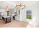 Bright kitchen featuring white cabinetry, stainless steel appliances, a dark island, and modern pendant lighting at 605 Arrow Point Ln, Davidson, NC 28036