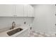 Functional laundry room with modern fixtures, white cabinetry, and a sink at 605 Arrow Point Ln, Davidson, NC 28036