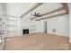 Spacious living room with a cozy fireplace, wooden beams, built-in shelving, and beautiful hardwood flooring at 605 Arrow Point Ln, Davidson, NC 28036
