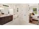Bright bathroom featuring a soaking tub, double vanity, and an open doorway at 6422 Chimney Bluff Rd, Lancaster, SC 29720