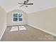 Spacious bedroom with neutral carpet, ceiling fan, and a large window overlooking the property at 6422 Chimney Bluff Rd, Lancaster, SC 29720