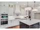 Modern kitchen boasts a large island, white cabinets, stainless steel appliances, and double pendant lights at 6422 Chimney Bluff Rd, Lancaster, SC 29720