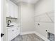 Well-lit laundry room with white cabinets, a sink, marble-look flooring, and wire shelving at 6422 Chimney Bluff Rd, Lancaster, SC 29720