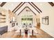 Living room featuring stone fireplace, vaulted ceilings with wood beams, and a wall of windows at 6422 Chimney Bluff Rd, Lancaster, SC 29720