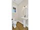 Chic powder room with a pedestal sink, round mirror, and hardwood floors at 6422 Chimney Bluff Rd, Lancaster, SC 29720