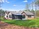 Stunning home exterior features a covered patio, lush lawn, mature trees, and impeccable landscaping at 6422 Chimney Bluff Rd, Lancaster, SC 29720