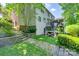 Beautiful backyard with a two-story deck, stone retaining walls, brick pavers, and lush greenery at 6804 Riesman Ln, Charlotte, NC 28210