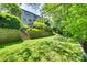 Expansive backyard featuring stone retaining walls, lush greenery, and access stairs at 6804 Riesman Ln, Charlotte, NC 28210