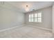 Neutral bedroom featuring plantation shutters, carpet, and a modern light fixture at 6804 Riesman Ln, Charlotte, NC 28210