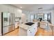 Open concept kitchen with stainless steel appliances, large island, and seamless flow to the dining area at 6804 Riesman Ln, Charlotte, NC 28210