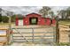 Well-maintained red barn with gate and star detail; ideal for equestrian use and rural living at 7514 Secrest Shortcut Rd, Indian Trail, NC 28079