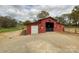 Spacious red barn with roll-up door and large opening, perfect for livestock or storage on this expansive property at 7514 Secrest Shortcut Rd, Indian Trail, NC 28079
