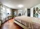 Bright bedroom featuring hardwood floors, decorative lighting, and a large display cabinet for showcasing collectibles at 7514 Secrest Shortcut Rd, Indian Trail, NC 28079