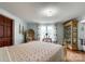 Sunlit bedroom with hardwood floors, accent chair, floral curtains, and display cabinet, providing a cozy, inviting atmosphere at 7514 Secrest Shortcut Rd, Indian Trail, NC 28079