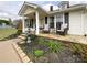 Inviting front porch with cozy seating, stone accents, a fountain, and colorful garden beds at 7514 Secrest Shortcut Rd, Indian Trail, NC 28079