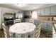 Functional kitchen featuring painted cabinets, floral tablecloth, and stainless steel appliances, blending style and practicality at 7514 Secrest Shortcut Rd, Indian Trail, NC 28079