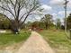 Beautiful property showcasing a charming barn and tree lined gravel driveway at 7514 Secrest Shortcut Rd, Indian Trail, NC 28079