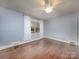 Bedroom with hardwood floors, one window with white curtains and baseboard heating at 848 Woodland Rd, Statesville, NC 28677
