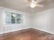 Bright bedroom with hardwood flooring, ceiling fan, window with sheer curtains, base trim and neutral walls at 848 Woodland Rd, Statesville, NC 28677