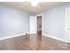 Bedroom with hardwood floors and view into the hallway, baseboard heating at 848 Woodland Rd, Statesville, NC 28677