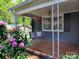 Cozy covered porch adorned with hanging swing and charming flower arrangements at 848 Woodland Rd, Statesville, NC 28677