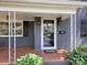 Inviting front porch with decorative railing and brick flooring leads to the front door at 848 Woodland Rd, Statesville, NC 28677