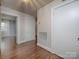 Hallway with hardwood floors and white trim with access to a bedroom and utilities at 848 Woodland Rd, Statesville, NC 28677