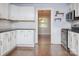 Open kitchen featuring white cabinets, subway tile backsplash, and stainless steel appliances at 848 Woodland Rd, Statesville, NC 28677