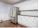Kitchen featuring stainless steel refrigerator, white cabinetry, and hardwood floors at 848 Woodland Rd, Statesville, NC 28677