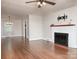 Spacious living room with a white brick fireplace, hardwood floors and modern light fixture at 848 Woodland Rd, Statesville, NC 28677