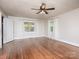 Bright living room featuring hardwood floors, ceiling fan, and natural light through large windows at 848 Woodland Rd, Statesville, NC 28677
