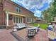 Charming backyard with a brick patio, outdoor seating, lush green lawn, and a beautiful brick home exterior at 8912 Heydon Hall Cir, Charlotte, NC 28210