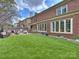 Expansive backyard featuring a brick patio with seating, a large lawn, and a classic brick home facade at 8912 Heydon Hall Cir, Charlotte, NC 28210
