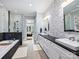 Bright bathroom featuring double sinks, a soaking tub with black brick accents, and glass enclosed shower at 8912 Heydon Hall Cir, Charlotte, NC 28210