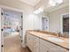 Bright bathroom featuring double sinks with stone countertop, and an entrance to the bedroom at 8912 Heydon Hall Cir, Charlotte, NC 28210
