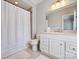 Bathroom boasts a shower with curtain, white cabinets and stone counter top with framed mirror at 8912 Heydon Hall Cir, Charlotte, NC 28210