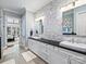 Bright bathroom featuring double sinks with dark countertops, tile backsplash, and an entrance to the bedroom at 8912 Heydon Hall Cir, Charlotte, NC 28210