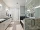 Modern bathroom featuring double sinks, tiled walls, and a glass-enclosed shower with natural light at 8912 Heydon Hall Cir, Charlotte, NC 28210