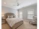 Bedroom featuring a ceiling fan, neutral walls, beige carpet, and upholstered bed at 8912 Heydon Hall Cir, Charlotte, NC 28210