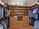 Spacious walk-in closet with custom built-in shelving, drawers, and hanging rods for optimal storage at 8912 Heydon Hall Cir, Charlotte, NC 28210