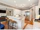Open concept kitchen with an island and bar seating, connecting to the living room and stainless appliances at 8912 Heydon Hall Cir, Charlotte, NC 28210